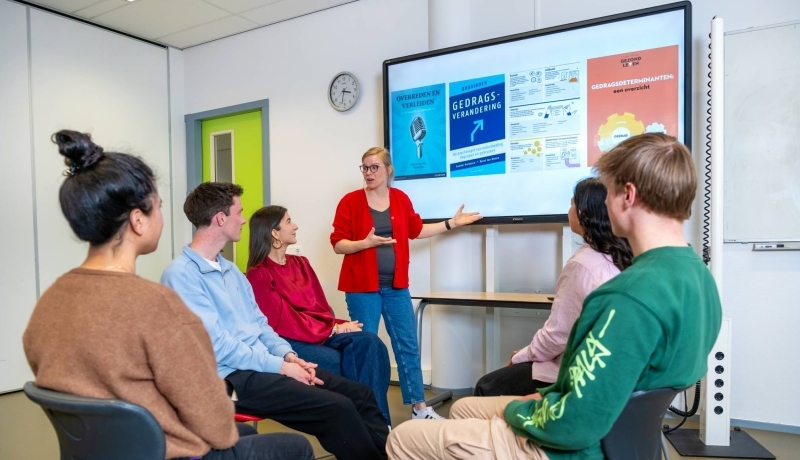 Docent Toegepaste Psychologie geeft uitleg aan studenten in een klaslokaal