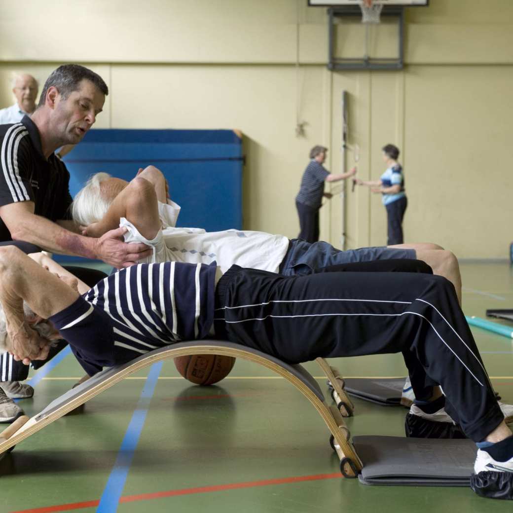 oudere mensen trainen met instructeur in het universitair sportcentrum