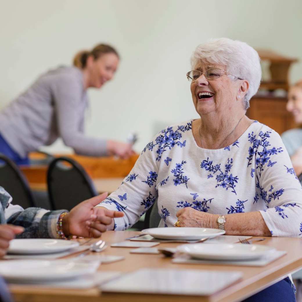 Lachende dame aan eettafel
