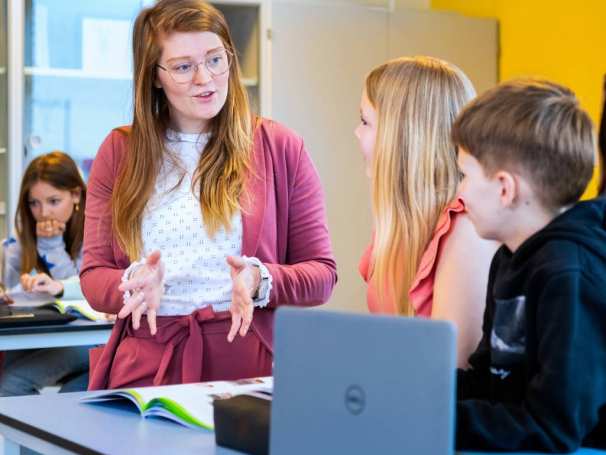 Fotoshoot op het Citadel 2024. De docent gebruikt gebaren om uitleg te geven aan een jongen en een meisje in de klas. 
