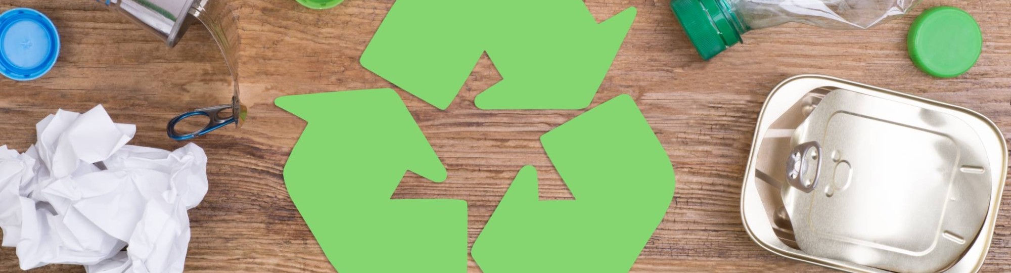 reclyvle teken met drie pijlen die elaar volgens en daaronder recyclebare spullen zoals blikjes en flessen en papier.