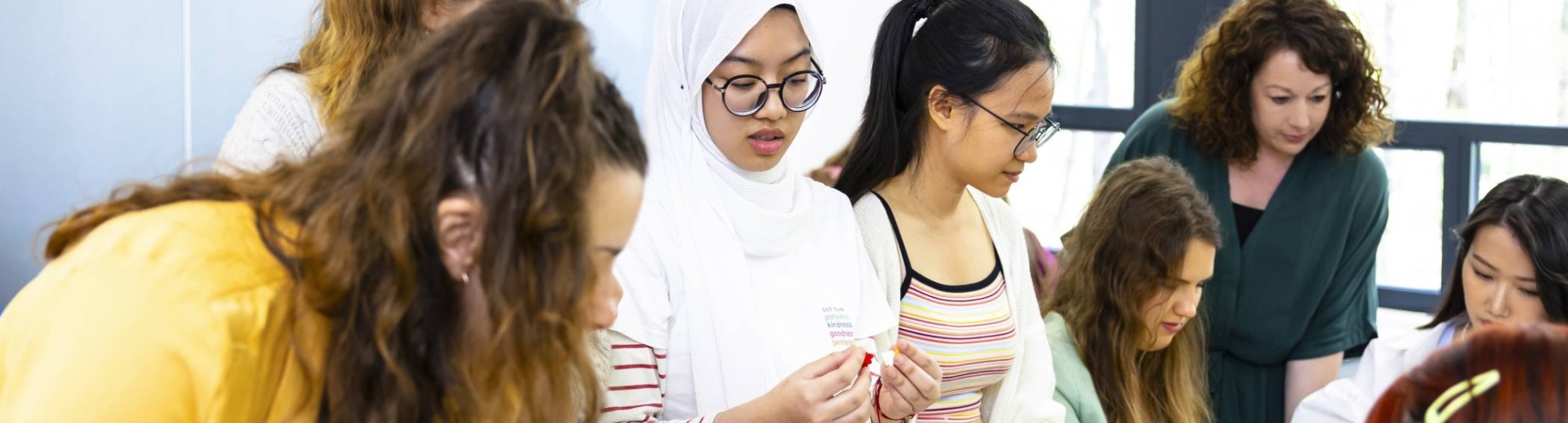 Studenten en Ingeborg samen aan het werk rond een tafel