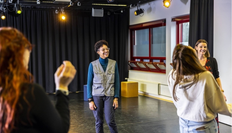 Een vrouwelijke student International Social Work lacht. Ze is bezig met het creatieve vak Drama.