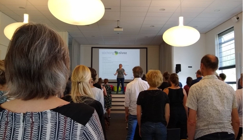 Bezoekers symposium Master Pedagogiek aandachtige betrokkenheid, krijgen les van een muziekpedagoog