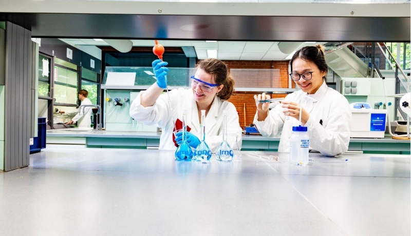 studenten pipetteren in het chemielab