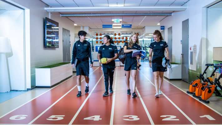Studenten lopen over de atletiekbaan