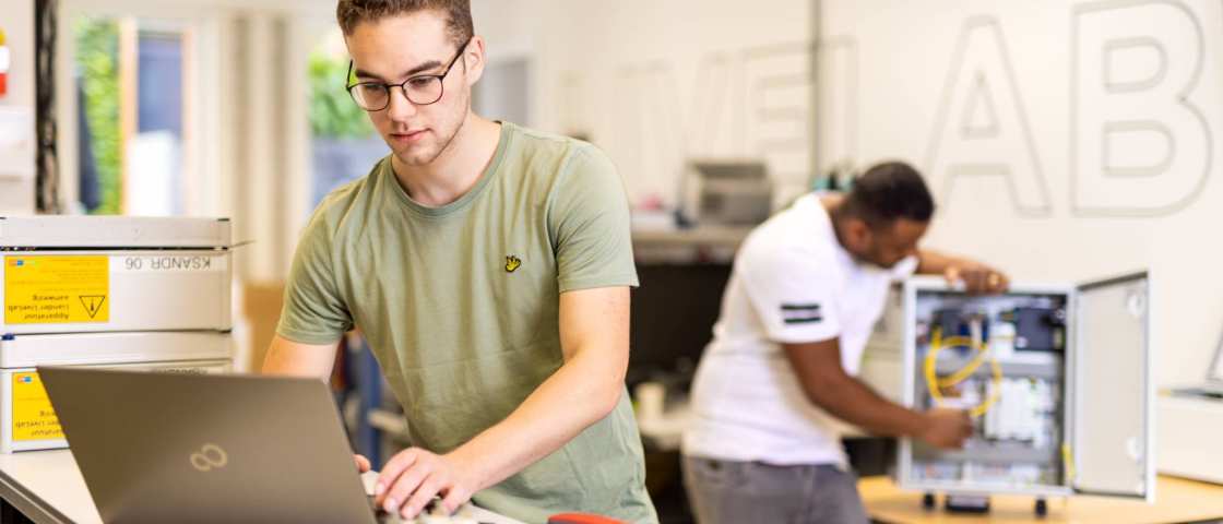 voltijdstudent Mik aan het werk op zijn laptop bij Qirion Alliander