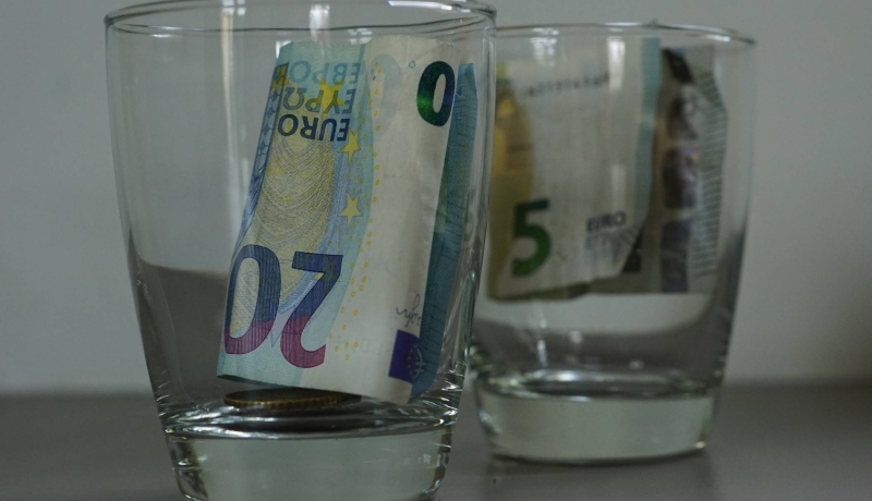 Armoede in beeld. Glazen met geld