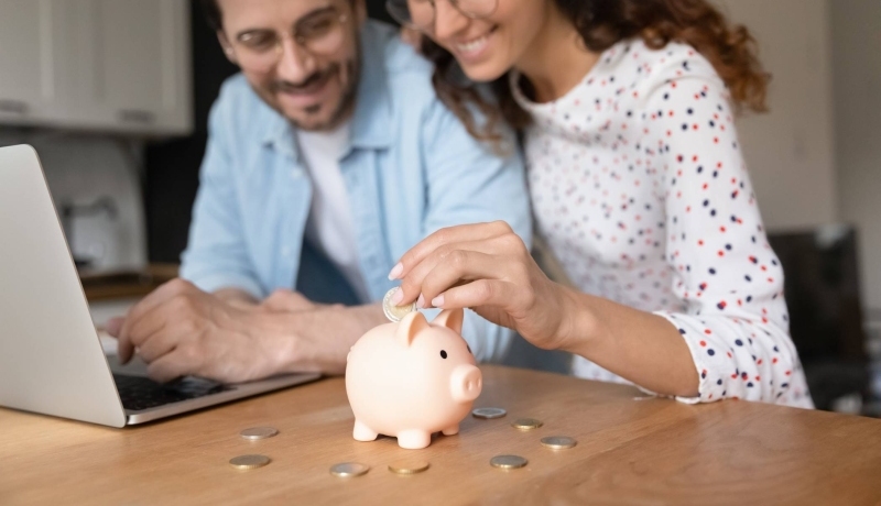 Man en vrouw doen geld in een spaarvarken