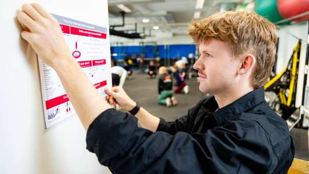 ad sport sportondernemer tom hangt poster op 2024