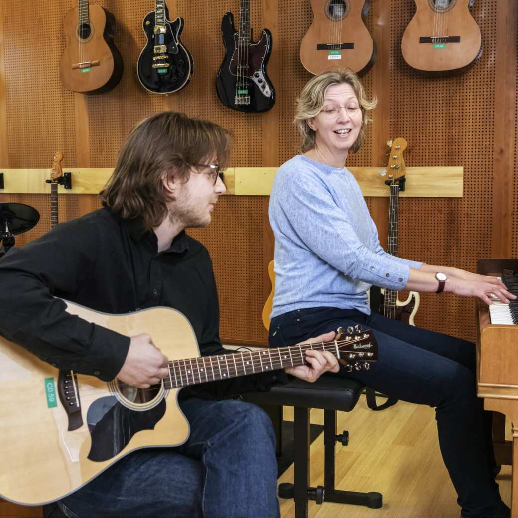2 studenten van de han master vaktherapie muziektherapie maken samen muziek op gitaar en piano
