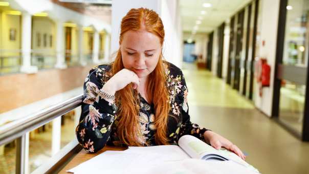 student vrouw leest boeken hal