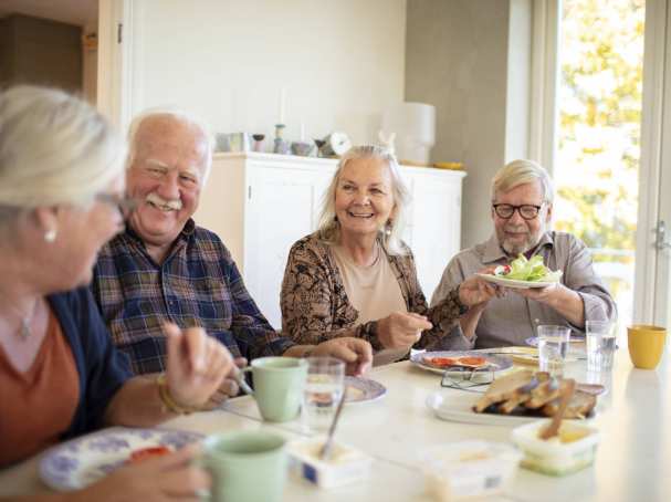 Groep ouderen aan tafel tijdens het ontbijt in een verpleeghuis