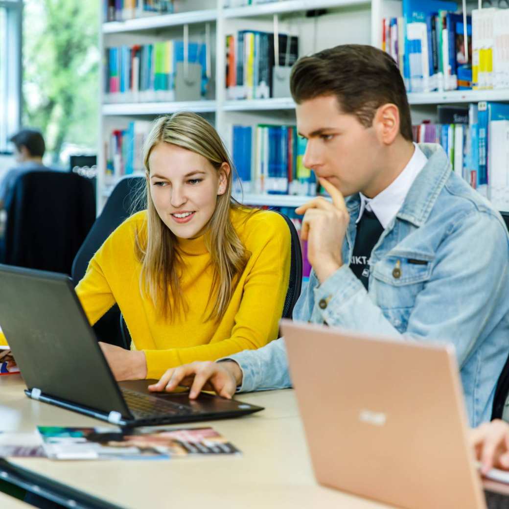 Twee deeltijdstudenten regelen de kosten van hun studie achter de laptop.