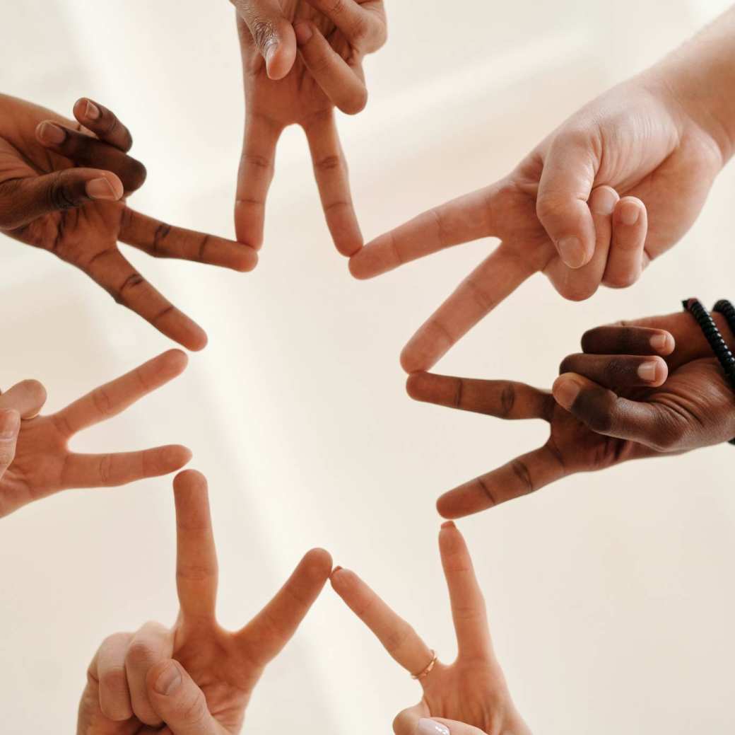 Handen in een kring vormen samen een ster. metafoor voor inclusie
