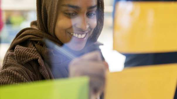 Health fotoshoot wijkcentrum student schrijft op plakbriefje