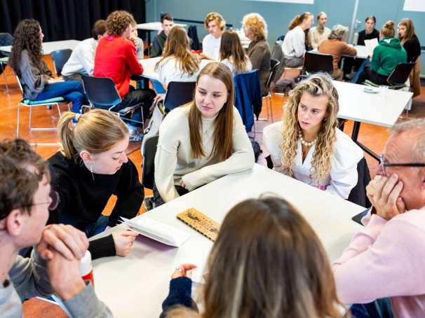 Studenten IPL luisteren naar het verhaal over armoede door een ervaringsdeskundige. Vervolgens spelen ze in groepjes, samen met de docenten en ervaringsdeskundigen, het spel Kansen Keren.