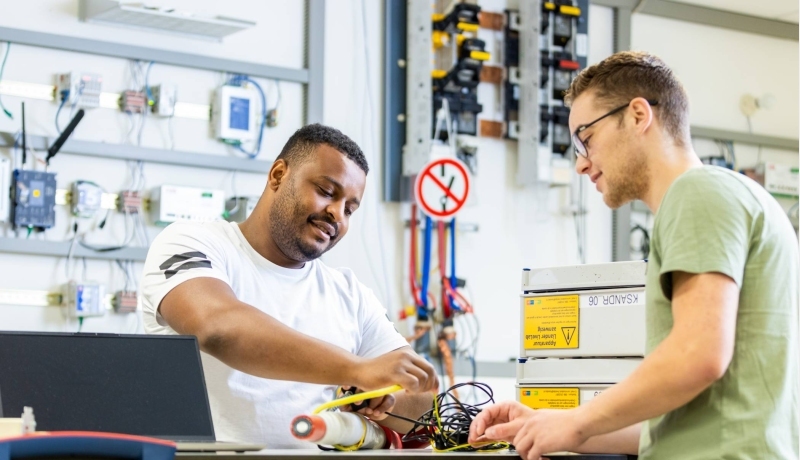 Twee deeltijdstudenten bezig met elektriciteitskabels.
