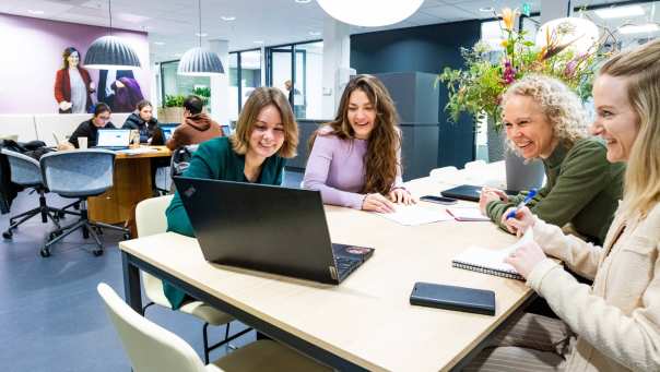 Post-hbo Bedrijfskunde, deelnemers werken samen aan een opdracht met laptop.