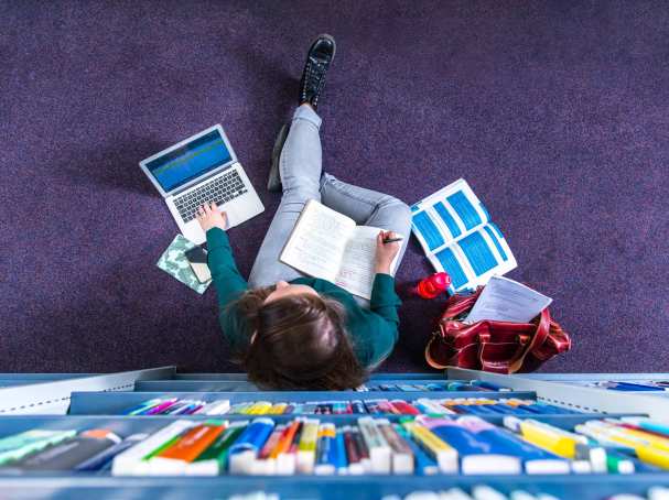 Studente studeren in studiecentrum en werken op laptop, van bovenaf
