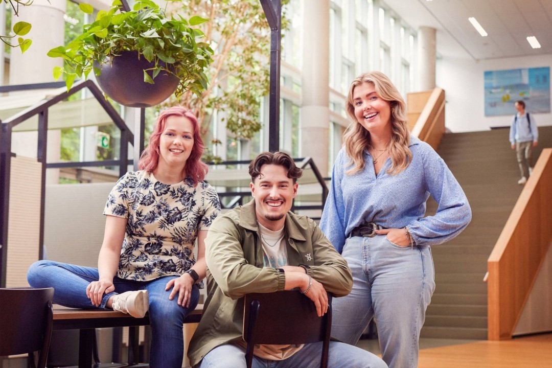 werving voltijd campagne, drie studenten in de hal kijken recht in de camera.