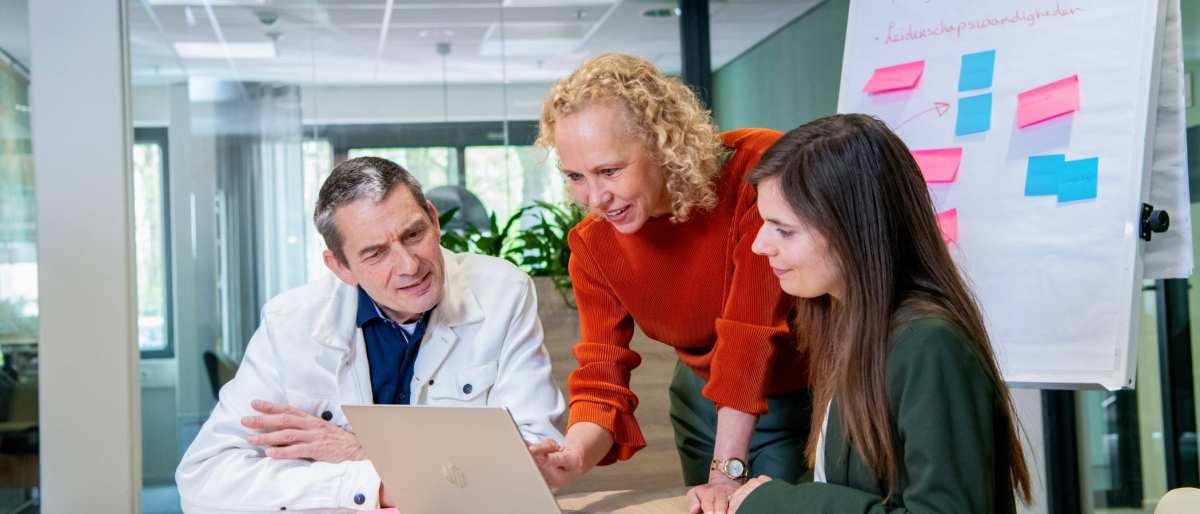 Deelnemers en docenten van de post-hbo Bedrijfskunde in overleg, lachend.