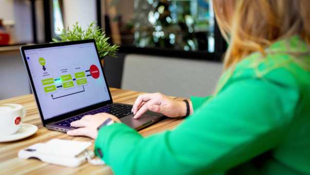 Student van de associate degree Commerciële Economie deeltijd, duaal aan het werk op laptop in HANgar.