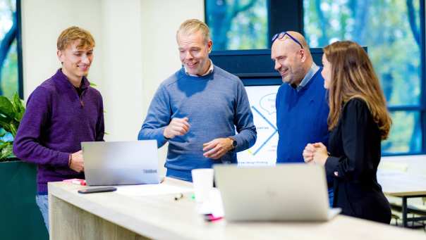 Studenten van de master Business Sales in overleg aan statafel.