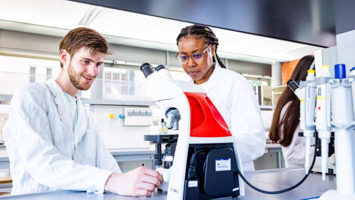 studenten aan het werk met een microscoop